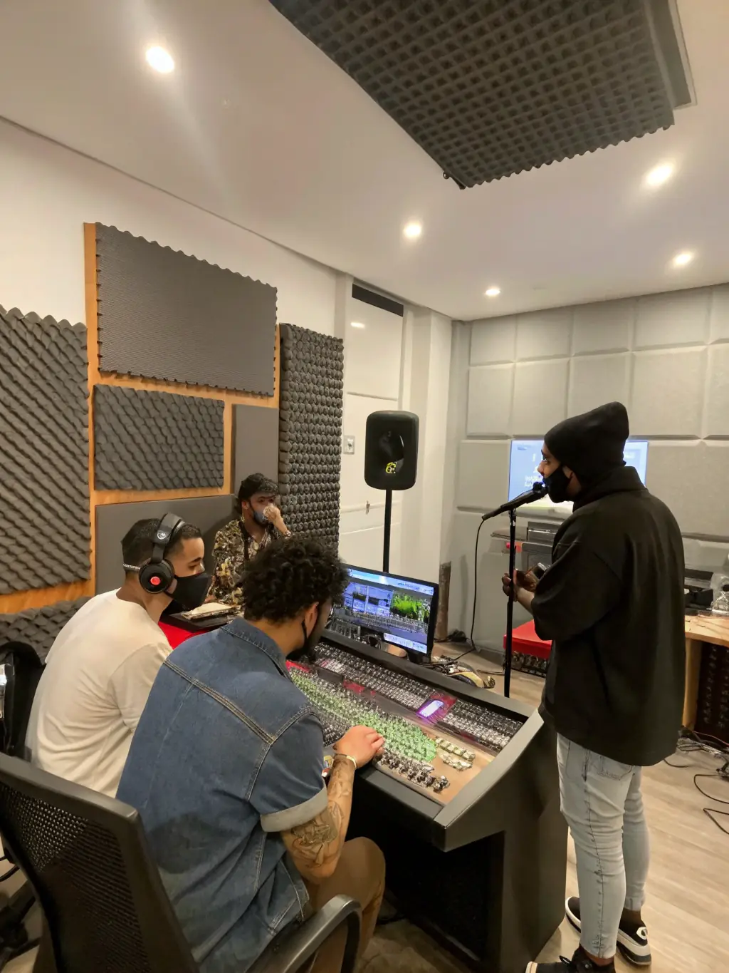 A professional recording studio scene, with artists recording their music as part of FORGIVE FORGIVE's music recording initiative.